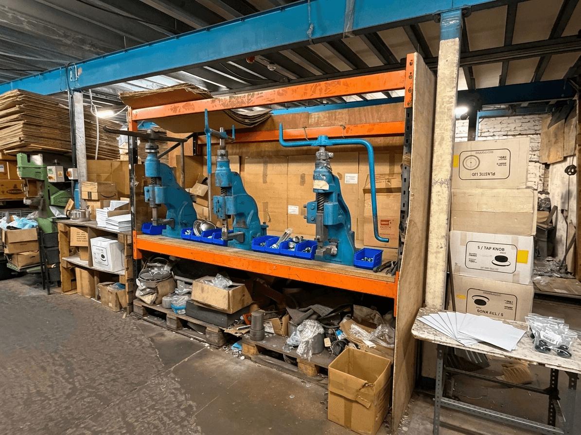 Row of precision hand presses used to shape cookware